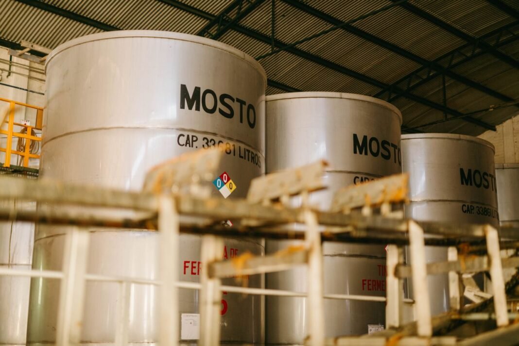 Interior view of an industrial tequila distillery with large metal containers labeled 'Mosto'.
