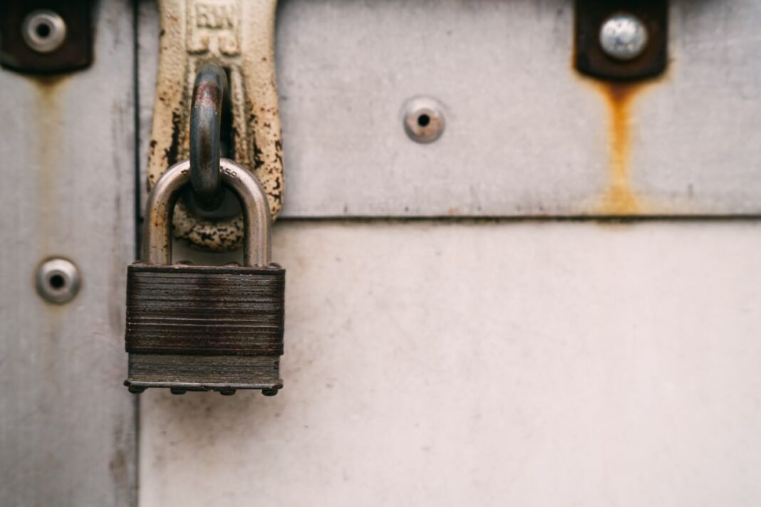 pexels-photo-18783946-18783946 Close-up of a rusty metal padlock on a weathered door, highlighting security and decay.