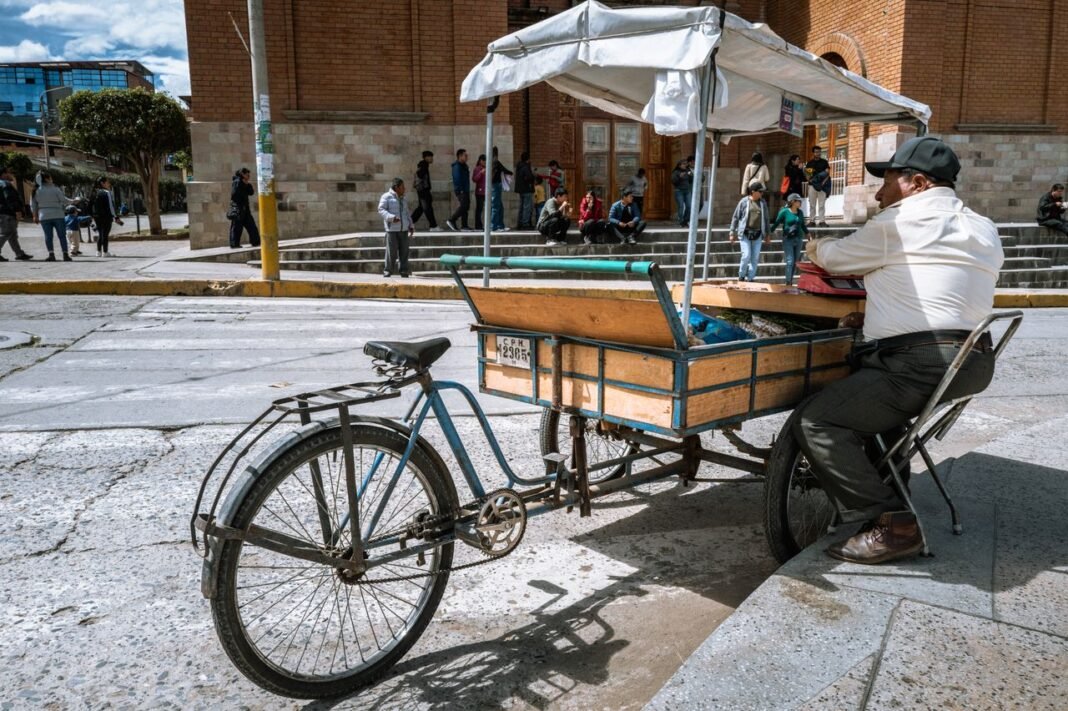 A street vendor with a bicycle cart waiting for customers in Trujillo, Peru on a sunny day.