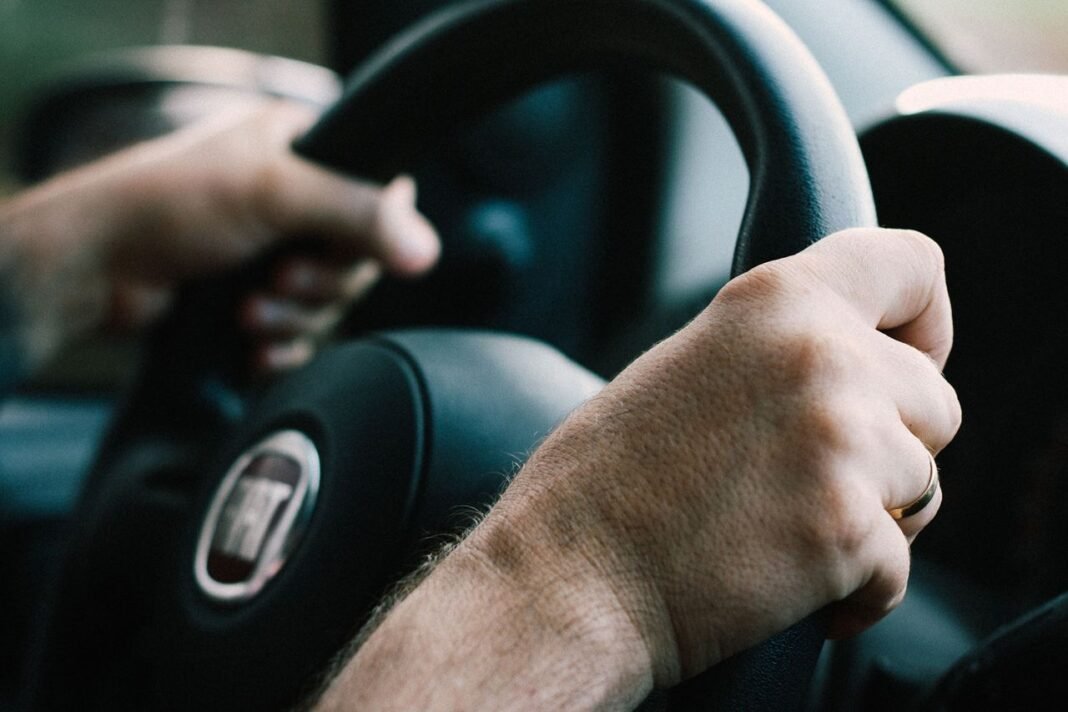 pexels-photo-2061417-2061417-1 Hands firmly gripping a car steering wheel, ready to drive.
