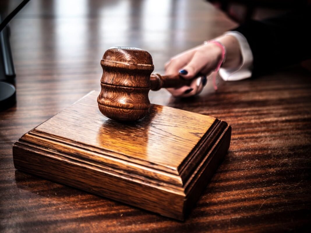 Close-up of a wooden gavel on a judge's desk, symbolizing justice.