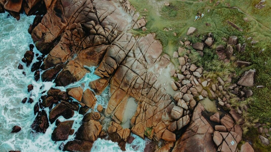 Breathtaking aerial shot of the rocky shoreline at Enseada da Pinheira, Brazil.